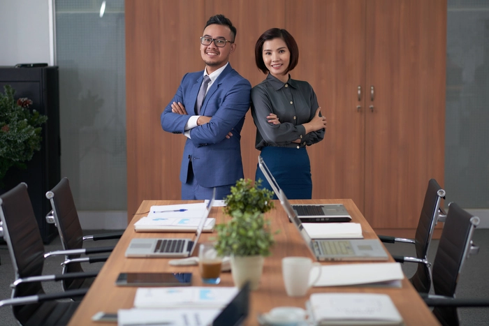 Two startup executives standing confidently in a boardroom, illustrating the process of hiring your first CEO and evaluating leadership for startup growth
