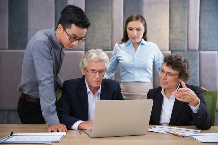Business professionals discussing strategy during a leadership coaching session in an office meeting