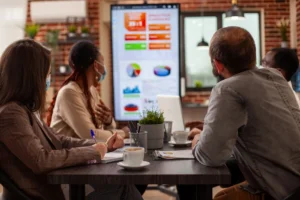 Team reviewing data dashboard and KPIs during performance management system discussion