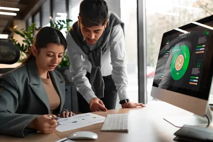 Team reviewing reports and dashboards during a performance management system discussion in the office