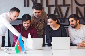 Team collaborating on laptops in an office setting, highlighting performance management systems and strategies to reduce micromanagement and improve team creativity.